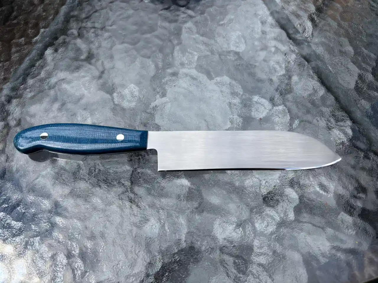Rear view of stainless steel chefs knife with admiral blue micarta handles
